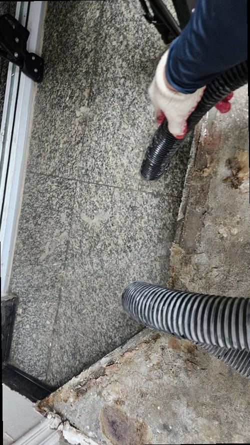 오산 누수탐지 베란다 바닥과 창틀 주변의 누수 흔적을 확인하는 모습